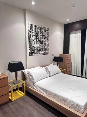 a bedroom with a bed and two lamps and a picture at The Sand Castle - Ubora Residence Tower, Business Bay, Burj Khalifa View in Dubai