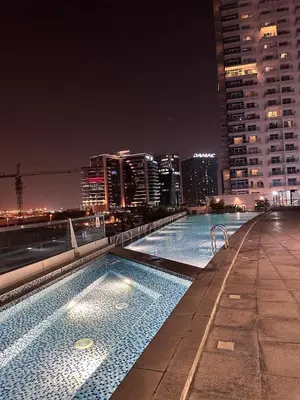 a swimming pool on the roof of a building at night at The Sand Castle - Ubora Residence Tower, Business Bay, Burj Khalifa View in Dubai