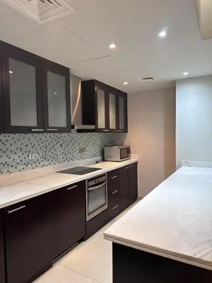 a kitchen with black cabinets and a white counter top at The Sand Castle - Ubora Residence Tower, Business Bay, Burj Khalifa View in Dubai