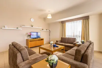a living room with two couches and a tv at Roda Amwaj Suites Jumeirah Beach Residence in Dubai
