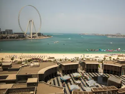 a view of a beach with a ferris wheel in the background at Roda Amwaj Suites Jumeirah Beach Residence in Dubai