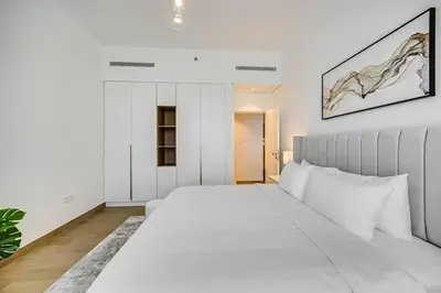 a white bedroom with a large white bed in it at Amazing 1 bedroom in Port De La Mer near the sea in Dubai