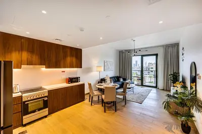 a kitchen and living room with a table and chairs at Amazing 1 bedroom in Port De La Mer near the sea in Dubai