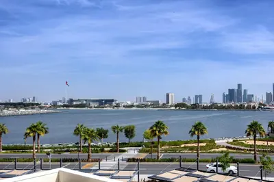 a view of a body of water with palm trees at Amazing 1 bedroom in Port De La Mer near the sea in Dubai