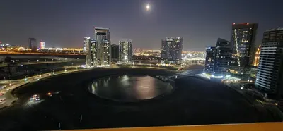 a city at night with a river and buildings at Elite 6 Residence - Sports City by Golden Casa in Dubai