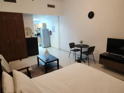 a living room with a couch and a table with chairs at Elite 6 Residence - Sports City by Golden Casa in Dubai