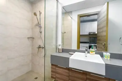 a bathroom with a sink and a shower with a mirror at Bloom Height - Amazing Pool - Good Wi-Fi in Dubai