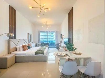 a bedroom with a bed and a table and chairs at Cool Studio near to Metro & Beach in Dubai Marina in Dubai