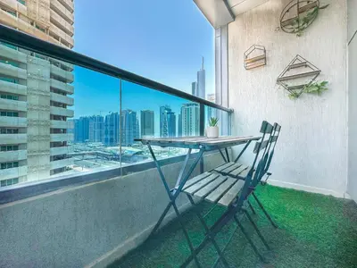 a table and a chair on a balcony with a view at Cool Studio near to Metro & Beach in Dubai Marina in Dubai