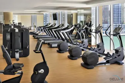 a gym with rows of treadmills and machines at Overlooking Marina Views Next to Marina Mall 1BR Unit, The Address Residences, Dubai Marina by Deluxe Holiday Homes in Dubai