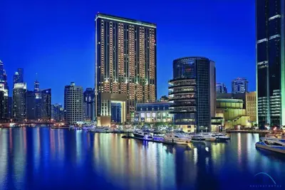 a city skyline with boats in the water at night at Overlooking Marina Views Next to Marina Mall 1BR Unit, The Address Residences, Dubai Marina by Deluxe Holiday Homes in Dubai