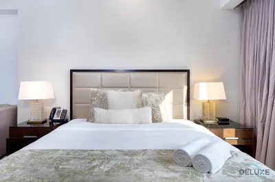 a bedroom with a large white bed with two lamps at Urban Studio at The Address Residences Dubai Marina by Deluxe Holiday Homes in Dubai
