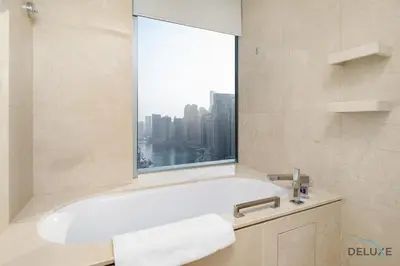 a bathroom with a bath tub and a window at Urban Studio at The Address Residences Dubai Marina by Deluxe Holiday Homes in Dubai