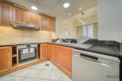 a kitchen with wooden cabinets and a white dishwasher at Urban 2BR at Al Mesk Tower Dubai Marina by Deluxe Holiday Homes in Dubai