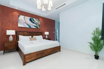a bedroom with a large wooden bed with white sheets at Lux BnB Paramount Midtown I Ocean View in Dubai