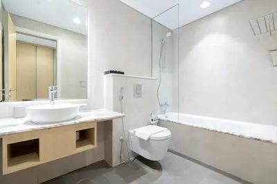 a bathroom with a sink and a toilet and a tub at Lux BnB Paramount Midtown I Ocean View in Dubai