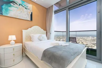 a bedroom with a bed and a large window at Lux BnB Paramount Midtown I Ocean View in Dubai