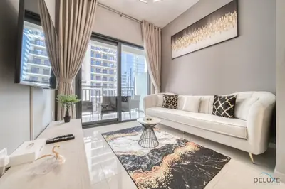 a living room with a couch and a large window at Limited Time Offer Modern 1BR at DAMAC Zada Tower by Deluxe Holiday Homes in Dubai