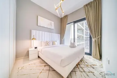 a white bedroom with a large bed and a large window at Limited Time Offer Modern 1BR at DAMAC Zada Tower by Deluxe Holiday Homes in Dubai