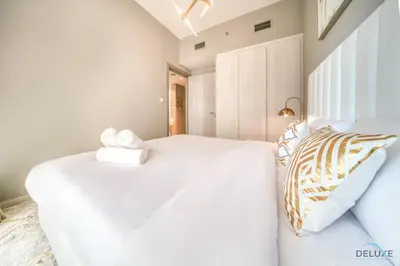 a bedroom with two white beds and a window at Limited Time Offer Modern 1BR at DAMAC Zada Tower by Deluxe Holiday Homes in Dubai