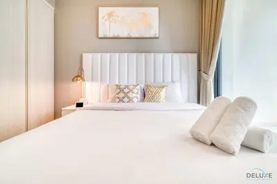 a bedroom with a large white bed with a window at Limited Time Offer Modern 1BR at DAMAC Zada Tower by Deluxe Holiday Homes in Dubai