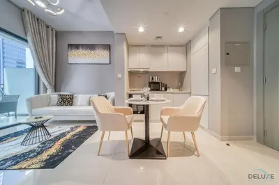 a living room with a table and chairs and a couch at Limited Time Offer Modern 1BR at DAMAC Zada Tower by Deluxe Holiday Homes in Dubai