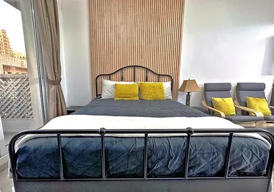 a bedroom with a bed with yellow pillows at Lovely Studio Apartment in Hanover Square, JVC in Dubai