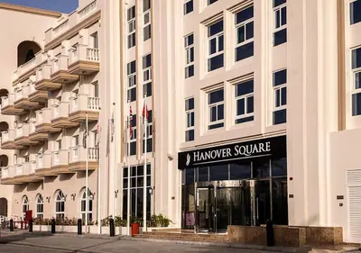 a large white building with a harvard square sign on it at Lovely Studio Apartment in Hanover Square, JVC in Dubai