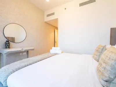 a bedroom with a white bed and a mirror at Phenomenal 2Br in Downtown Views II in Dubai