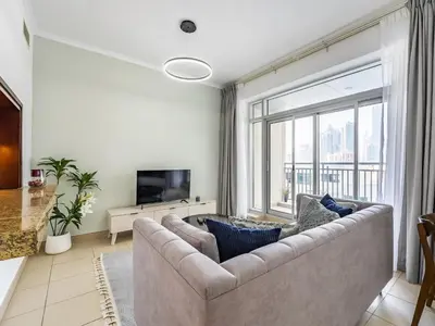 a living room with a couch and a large window at Incredible Studio In Burj View in Dubai