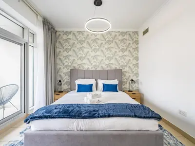 a bedroom with a large bed with blue pillows at Incredible Studio In Burj View in Dubai