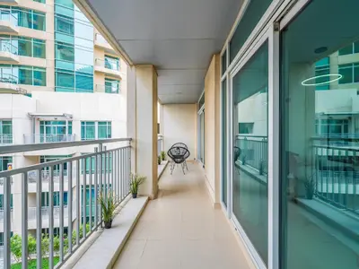 an empty corridor of a building with a chair on a balcony at Incredible Studio In Burj View in Dubai