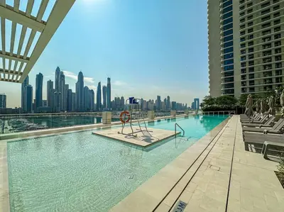 a swimming pool with a city skyline in the background at HiGuests - Emaar Beachfront Haven with Majestic Marina Views in Dubai