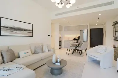 a living room with a white couch and a table at HiGuests - Emaar Beachfront Haven with Majestic Marina Views in Dubai
