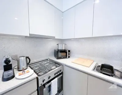 a small kitchen with a stove and a microwave at Incredible stay at Burj Royale Downtown in Dubai