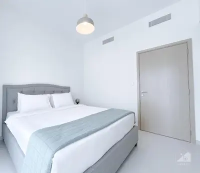 a white bedroom with a large bed and a door at Incredible stay at Burj Royale Downtown in Dubai