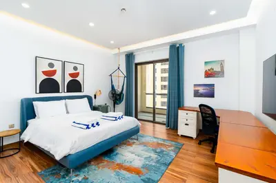a bedroom with a blue bed and a desk and a desk at JBR Bahar Beach Views 4 beds - DVH Holiday Homes in Dubai