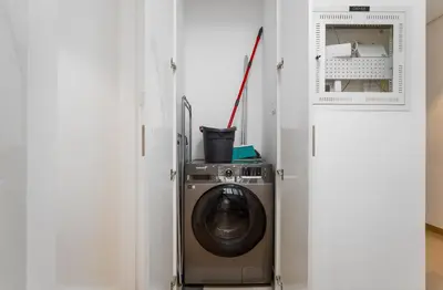 a washer and dryer in a white room at Nasma Luxury Stays - Home-Style 2BR Apartment with a Balcony View in Dubai