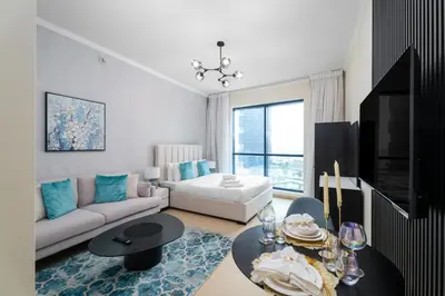 a living room with a couch and a table at Nasma Luxury Stays - Sophisticated Studio Apt with Stunning Marina View in Dubai