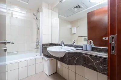 a bathroom with a sink and a bath tub at Nasma Luxury Stays - Sophisticated Studio Apt with Stunning Marina View in Dubai