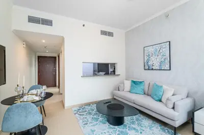 a living room with a couch and a table at Nasma Luxury Stays - Sophisticated Studio Apt with Stunning Marina View in Dubai