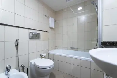 a bathroom with a toilet and a tub and a sink at Nasma Luxury Stays - Sophisticated Studio Apt with Stunning Marina View in Dubai