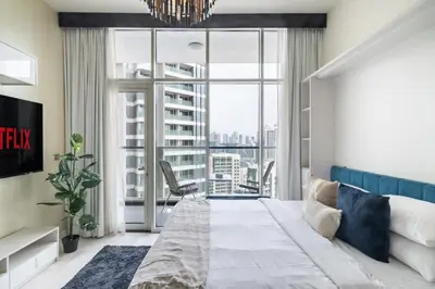 a bedroom with a bed and a large window at GuestReady - Lavish studio with Burj Khalifa views in Dubai