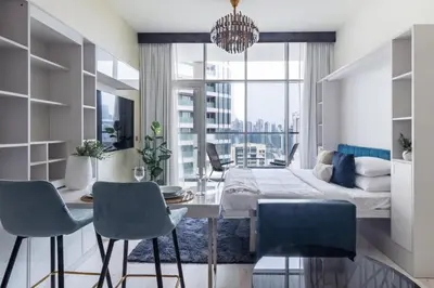 a dining room with a table and chairs and a bed at GuestReady - Lavish studio with Burj Khalifa views in Dubai