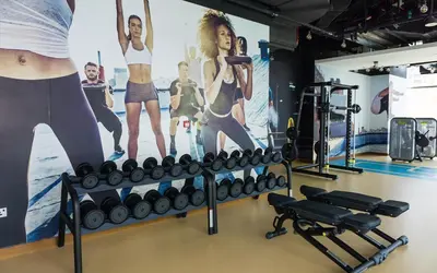 a gym with a rack of dumbbells and a poster at Dubai Marina Gate 2 Deluxe Apartment in Dubai