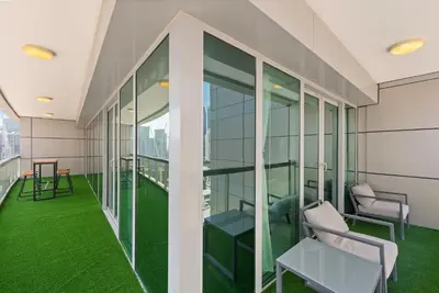 a balcony with green grass and chairs on a building at FIRST CLASS 2BR with Full Boulevard View in Dubai