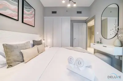 a bedroom with a large white bed and a mirror at Special Deal Scenic 1BR Close to Burj Khalifa by Deluxe Holiday Homes in Dubai