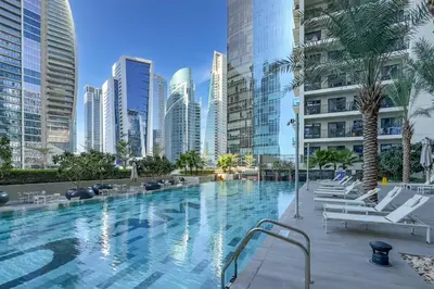 a large swimming pool in a city with tall buildings at Special Deal Scenic 1BR Close to Burj Khalifa by Deluxe Holiday Homes in Dubai