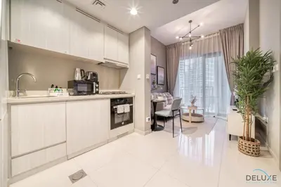 a kitchen with white cabinets and a dining room at Special Deal Scenic 1BR Close to Burj Khalifa by Deluxe Holiday Homes in Dubai