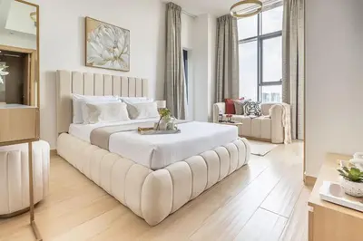 a large white bed with a large couch in a room at Frank Porter - Regina Tower in Dubai